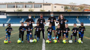 Els jugadors de l'escoleta amb  els seus entrenadors, la regidora d'esports i el presidnet del club, lluint la samarreta amb la mascota