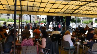 La gent, a l'ombra en el ball vermut