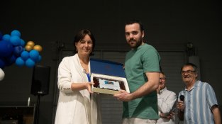 La representant territorial d'esports, Anna Julià, lliura a Xavier Casabó una placa en agraïment al treball fet amb el libre 111 anys de futbol a Cassà