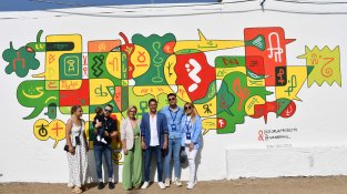El candidat del PP, Antonio Ávila, i la seva família, davant del mural que s'ha pintat a les portes del col·legi electoral de l'Escorxador