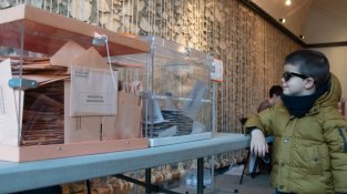 Un nen mirant les urnes al col·legi de la Sala de la Coma