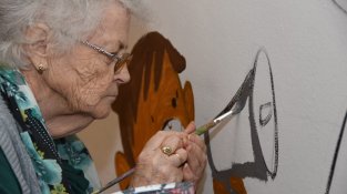 Una de les participants més grans, pintant el mural