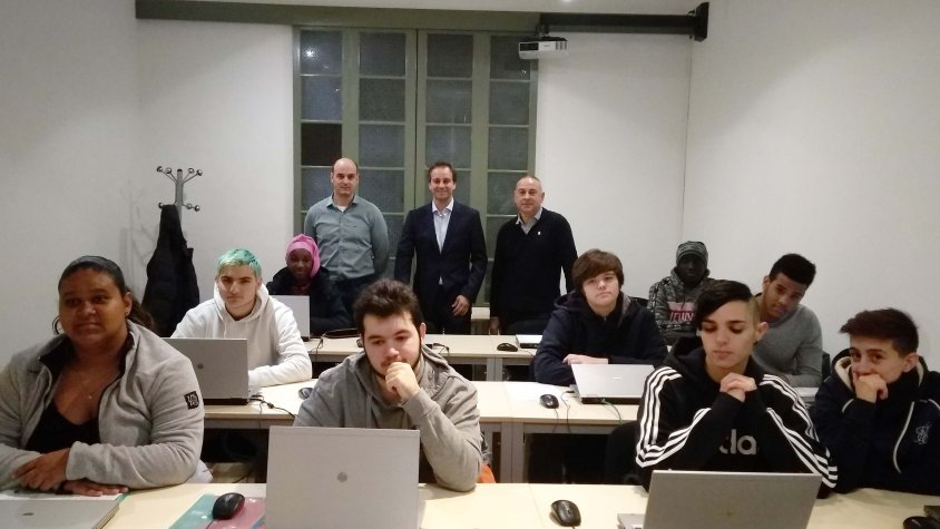 Alumnes dels cursos de mosso de magatzem i ajudant de cambrer a l’aula d’informàtica de Can Trinxeria a Cassà de la Selva. Darrere els alumnes, durant la visita que van fer dimarts, a la dreta, Robert Mundet, alcalde de Cassà de la Selva; al mig Eduard Bo