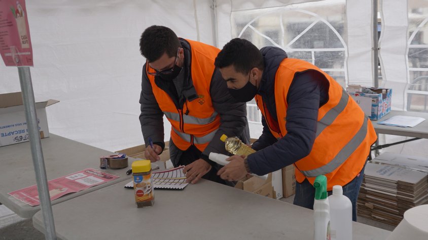Dos voluntaris classificant aliments en una de les carpes del gran recapte aquest migdia