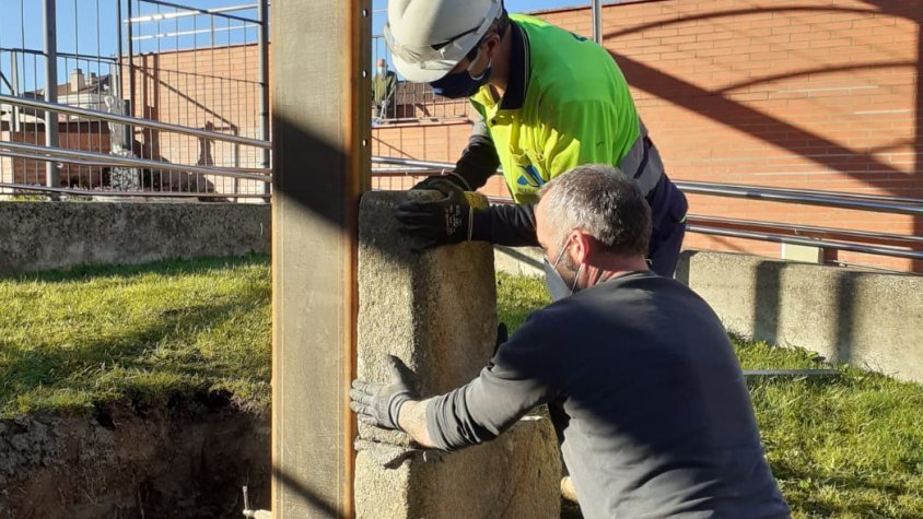 Uns operaris col·locant les pedres a l'estructura metàl·lica que les mantindrà a lloc