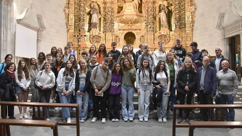 Els alumnes catalans i alemanys, amb professors i membres del GREC, davant el retaule de l'eglésia